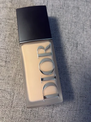 Dior Forever Skin Wear Foundation 2N - Dior Forever Skin Wear Foundation i nyansen 2N. Flytande foundation i en rektangulär glasflaska med svart lock och silverfärgad Dior-logga. Ger en naturlig finish och har SPF 25. Innehåller hyaluronsyra, niacinamid och peptider.