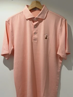 Holderness & Bourne piké - Snygg ljusrosa och vitrandig pikétröja från Holderness & Bourne i Signature Fit. Tröjan har klassisk krage och korta ärmar, perfekt för golf eller andra sportaktiviteter. Tillverkad i ett mjukt och lätt material som andas.