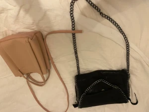 Svart kedjeväska och beige bucket bag - Rosa bandet är avklippt så den är trasig av nån andels ung vet ej om det går att fixa. Går att köpa enskilt men skickar gärna med den andra gratis. Inte riktigt Stella McCartney.