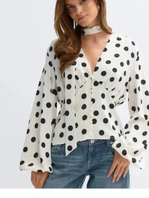 Populär Prickig blus med knytband från Gina  - Trendig Prickig blus från Gina som är slutsåld i alla storlekar. Hör av er för fler bilder. Aldrig använd. Blusen har en skarp med som man får på sidan. Man kan ha den med eller ta bort den