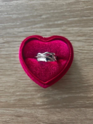 Silverfärgad ring med flätad design - ring i storlek 18,1mm, silverfärgad. 