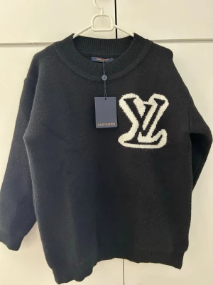 Stickad tröja - stickad tröja i clean svart design med stor L och V logo fram och bak. Tyvärr lite för liten för mig, därför säljs den vidare. Passar perfekt för någon runt 165–175 cm beroende på hur man vill att den ska sitta. Kvaliteten är top, väldigt skön och sticker ut på ett snyggt sätt.