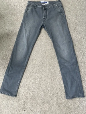 Gråblå raka jeans från Jacob Cohen - Snygga gråblå jeans från Jacob Cohen med raka ben och klassisk femficksmodell. Jeansen har en diskret tvättad look och stängs med dragkedja och knapp. Perfekta för en avslappnad stil och tillverkade i mjukt denimtyg.