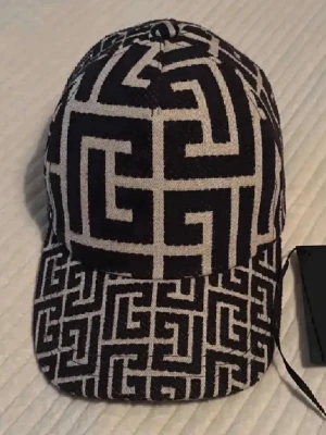 Balmain keps  - Säljer en otroligt snygg keps från Balmain köpt från NK. Har aldrig använt kepsen då den inte passar in i min stil. Skick: 10/10. Nypris: 4 449kr. Väldigt snygg och unik keps! KVITTO FINNS!