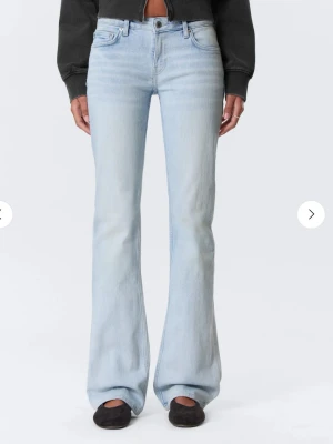 Ljusblå bootcut jeans från Weekday - Säljer ett par ljusblå bootcut jeans från Levi's med klassisk femficksmodell och hög midja. Jeansen har en snygg utsvängd passform och är tillverkade i mjuk denim med lite stretch för extra komfort. Perfekta för en avslappnad och trendig look. Storleken står inte i jeansen så jag vet inte men skulle säga M/L och midjemåttet är ca 41cm o innerbenslängden 84cm men de är ganska stretchiga 