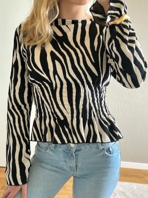 Zebramönstrad långärmad topp - Snygg zebramönstrad topp med lång ärm och markerad midja. Slutsåld hos Gina Tricot 🌸