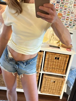 Ny ljus gul topp ärmlös  Gina Tricot - Säljer en j Gina Tricot med korta ärmar och mjukt, stretchigt material. Toppen har en hög krage och en enkel, stilren design som passar till många olika looks. Stl L