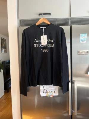Svart långärmad topp Acne Studios - Acne Studios Stockholm 1996 Long Sleeve  Helt ny med tags kvar. Stilren svart long sleeve med ikoniskt Stockholm 1996-tryck. Tillverkad i Portugal och i mycket hög kvalitet.  Storlek: xs Skick: Nytt Pris: 1050 kr  Öppen för seriösa bud.