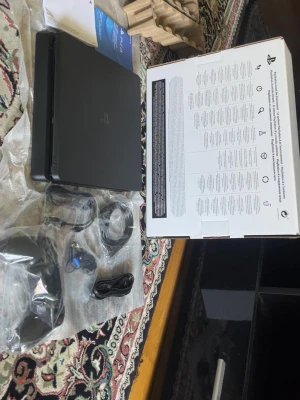 Sony PlayStation 4 Slim konsol svart - Säljer en svart PlayStation 4 Slim från Sony. Konsolen har en stilren, tunn och rektangulär design i matt plast. Medföljer gör strömkabel, HDMI-kabel, USB-kabel och en svart handkontroll. Perfekt för gaming och streaming.