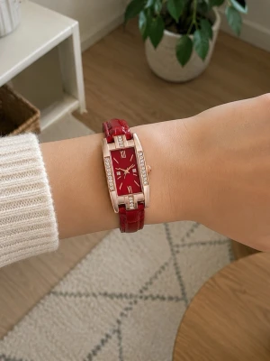 Röd rektangulär klocka med strass - Stilren klocka med rektangulär röd urtavla och matchande rött armband i läderimitation. Boetten är guldtonad och dekorerad med gnistrande strass på sidorna. Urtavlan har romerska siffror och tunna visare för en elegant look.
