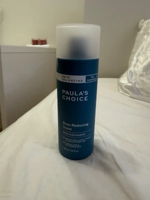 Paula's Choice Pore-Reducing Toner - En blå toner från Paula's Choice med matt plastlock. Produkten är en pore-reducing toner med niacinamid, speciellt framtagen för fet och kombinerad hud. Flaskan rymmer 190 ml och har en stilren, modern design.