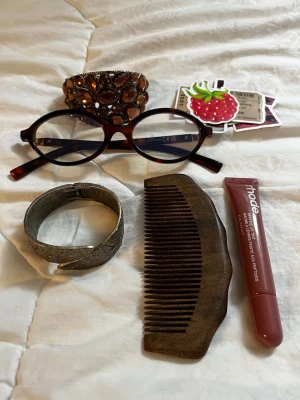 Brett armband med bruna stenar - Säljer ett brett armband dekorerat med stora, bruna glittrande stenar i flera rader. 2st armband. Perfekt för dig som vill sticka ut med accessoarerna! Rhode lip tint, mini kam, stickers, glasögon