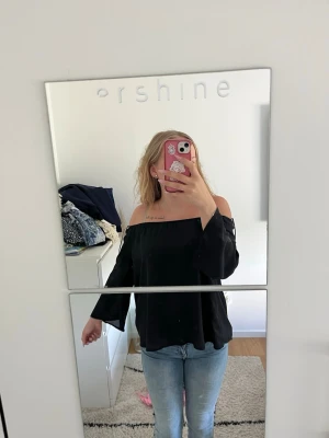 Svart offshoulder topp från Bik Bok - Säljer en svart offshoulder topp från Bik Bok i storlek XS. Toppen har vida ärmar och en lös passform som ger en chill vibe. Perfekt att styla med jeans eller kjol för en trendig look.