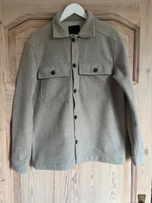 Grå overshirt med fickor - Stilren grå overshirt i fleece, storlek S, skick 9/10 inga konstigheter. . Perfekt för sena sommarkvällar 