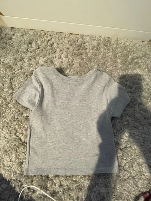 Ljusgrå basic t-shirt - Ljusgrå tröja från new Yorker. Tröjan är lite kort. Slutar vid naveln ungefär. Det står storlek medium på tröjan men jag är storlek S och den passar perfekt. 