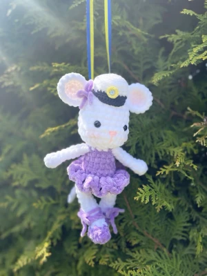 Unik virkad mus för studenthänga🧸🎉 - Söt handvirkad mus i vitt garn med lila klänning och matchande skor. Musen har en studentmössa med gul detalj och en liten rosett på huvudet. Hängs upp med blågult band, perfekt som dekoration eller present till studenten.
