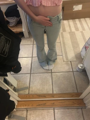 Ljusblå bootcut jeans - Säljer ett par ljusblå bootcut. Jeansen har en snygg, utsvängd passform nertill och är tillverkade i denim. De passar tyvärr inte mig längre och därför är inte gylfen stängd. Använda max 5 ggr