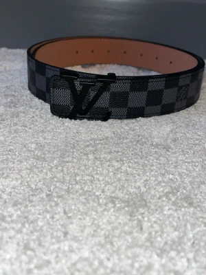 Zara rutig svart bälte - Snyggt bälte från Zara med klassiskt rutigt mönster i svart och grått. Bältet har svart metall som spänne och är gjort i skinn. Perfekt accessoar för att lyfta din outfit.