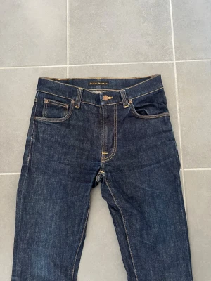 Blå Nudie Jeans - Nudie Jeans för män, passformen är slim-fit. Storlek Waist 30 / Lenght 34. Mycket bra skick inga skador/slitage. Hör av dig vid intresse/frågor. PRIS KAN DISKUTERAS!