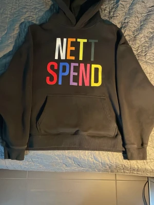 Svart hoodie med färgglad text - Svart Nett Spend hoodie. Jätte skön. Storlek L men passar M också om du gillar ganska baggy. Den kommer fortfarande vara lite baggy om du är L för den är en baggy hoodie. Om du gillar hoodies inte jätte baggy passar XL också.