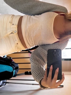 Grå stickad bolero - Säljer en grå stickad bolero med lång ärm och öppen front. Kort modell som passar perfekt över linne eller t-shirt. Mjuk och skön, ribbstickad struktur. Perfekt för lager-på-lager-stil.