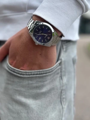 Silverfärgad Doventi klocka med blå urtavla - Doventi - Helt ny och oanvänd klocka i toppskick! Levereras komplett med originalbox. Perfekt skick, garanterat utan defekter. justering för optimal passform. Snabb leverans samma dag – direkt till dig!