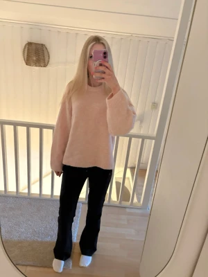 Ljusrosa stickad tröja Gina Tricot - Mysig ljusrosa stickad tröja från Gina Tricot med rund halsringning och ribbade muddar. Tröjan har en avslappnad passform och är perfekt för lager-på-lager. Tillverkad i mjukt material som känns skönt mot huden.