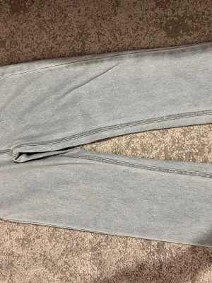 Ljusblå raka jeans - Säljer ett par ljusblå jeans med raka ben och klassisk femficksdesign. Jeansen har dragkedja och knapp med stjärndetaljer i silver. Tillverkade i denim med synliga sömmar. Perfekta för en avslappnad och trendig look. Den passar barn 158-164. Själv har jag bara använt den några fåtal eftersom inte min stil längre 