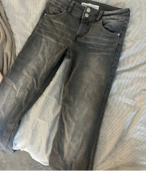 Grå jeans från Bershka - Snygga grå jeans från Bershka med klassisk femficksmodell och utsvängda.