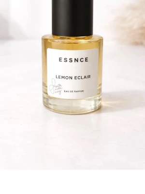 ESSNCE Lemon Eclair Eau de Parfum - Fräsch parfym från ESSNCE med doft av Lemon Eclair. Flaskan är rund och genomskinlig med gul vätska och svart lock. Modern och stilren design, perfekt för dig som gillar citrusdofter. Limited edition som inte går att köpa längre, helt oanvänd och aldrig sprayad med