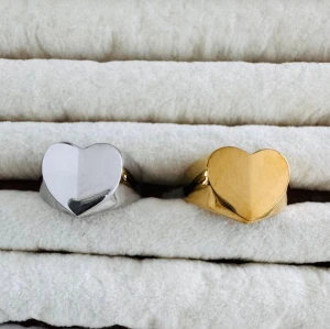 Hjärtringar i silver och guld - Två stilrena ringar med hjärtformad front, en i blankt silverfärgat material och en i glänsande guldton. Perfekt för dig som vill ha en enkel men snygg accessoar med romantisk touch. Materialet är metall och designen är modern och ungdomlig.