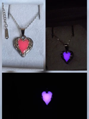 Självlysande hjärtformat halsband - Hansgjort halsband med hjärtformat hänge i silverfärgad metall och rosa insida som lyser lila i mörker. Kedjan är tunn och justerbar i rostfritt stål. Perfekt för dig som gillar unika accessoarer med cool glow-effekt. Effekten aktiveras av vanligt dagsljus och solljus. Lyser vanligtvis i flera timmar vid normal användning. Lång livslängd. Både kedjan & hänget tål vatten o missfärgas ej. Hängets storlek är ca 1,8 cm. 