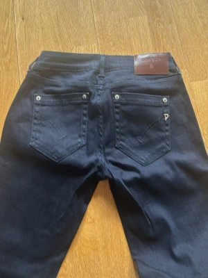 Mörkblå slim fit jeans - Snygga mörkblå slim fit jeans med klassisk femficksdesign och raka ben. Jeansen har metallnitar vid fickorna och är tillverkade i ett stretchigt denim-material som ger en skön passform. Perfekt för dig som gillar en stilren look.