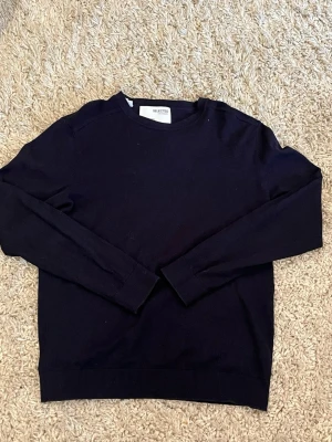 marinblå tröja från Selected Homme - En stilren mörkblå tröja från Selected Homme med rund halsringning och långa ärmar. Tröjan är tillverkad i 100% bomull och har ribbade muddar vid ärmslut och nederkant. Perfekt för en clean och enkel look. har ett litet hål i armhålan som lätt går o laga 