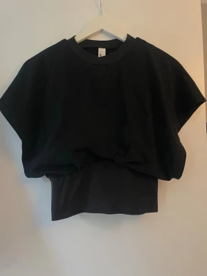 Svart croppad topp med loose fit - Säljer en svart croppad topp från shein med loose fit och breda ärmar. Toppen har en rund halsringning och är tillverkad i mjuk bomull. Finns även ett ytterligare lager i tröjan som extra stöd. Perfekt för dig som gillar en avslappnad och trendig stil.