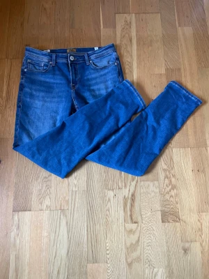 Blå bootcut jeans från Jack & Jones - Snygga blå bootcut jeans från Jack & Jones med klassiska fem fickor och ljus tvätt. Jeansen är i bra skick! På jeansen är storleken 170 & 15y men skulle gissa att det är 30/32! Tveka inte att höra av er!🌟