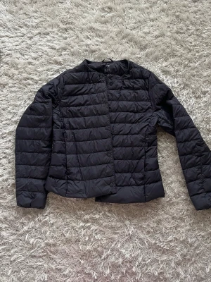 Mörkblå dunjacka från Uniqlo - Mörkblå dunjacka från Uniqlo, nypris 749kr. Den är ganska tunn så perfekt till våren! En liten påse ingår också som man kan packa ner jackan i. 