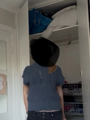Blå stickad topp med hålmönster - Snygg blå stickad topp med korta ärmar och coolt hålmönster framtill. Tröjan har en hög ribbad krage och ribbade detaljer vid nederkant och ärmslut. Perfekt för dig som gillar en avslappnad och trendig look. Skriv gärna om ni har några mer funderingar eller om flera bilder 