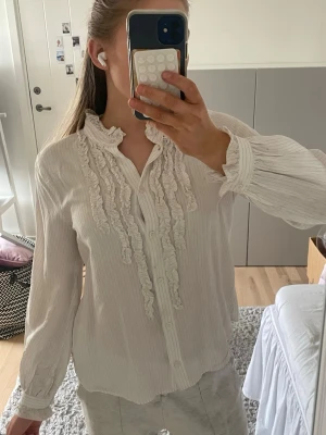 Blus  - Snygg vit blus med tunna svarta ränder. 