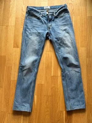 Acne Studios Jeans - Säljer ett par klassiska blå jeans från Acne Studios, modell Max LT Vintage 30x34. Jeansen har rak passform, tillverkade i 100% bomull. Snygg tvätt med lätt slitning på låren för en vintagekänsla. 