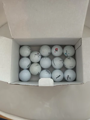 Box med vita golfbollar Wilson - Säljer en box med flera vita golfbollar från Wilson. Bollarna har klassisk rund form och är tillverkade i slitstarkt material med dimple-mönster för bättre flyg. Perfekt för dig som vill fylla på golfutrustningen.