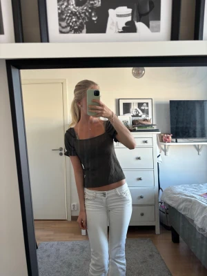 mörk grön blus med puffärm - Säljer en mörk grön blus med fyrkantig halsringning och korta puffärmar. Toppen är croppad och har en slim passform som framhäver figuren. Perfekt för dig som gillar stilrena och trendiga plagg.