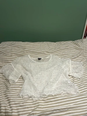 Vit spetsblus med korta ärmar - Säljer en vit blus från lindex i spets och korta ärmar. Skitsnygg att ha över ett vitt linne på sommaren💕