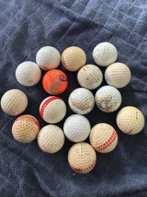 Samling med golfbollar, blandade färger - Säljer en samling med 17 golfbollar i olika färger och mönster, mestadels vita men även några med röda och orange inslag. Bollarna har klassisk rund form och är tillverkade i hård plast med dimple-mönster. Perfekt för dig som vill fylla på golfutrustningen.