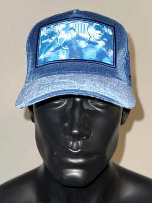 FC Barcelona x Messi – Exklusiv Trucker Cap! ⚽️🔥 - Visa ditt stöd för Barça med denna unika keps! Fronten pryds av en ikonisk bild på Messi i en snygg sammetsfinish. ✅ Design: Välj mellan färg eller svartvitt tryck på glittrande blå eller klassisk svart keps. ✅ Komfort: Klassisk trucker-modell med luftigt nät och justerbar passform. ✅ Skick: Helt ny! Perfekt för alla Barça-fans som vill bära klubbens färger med stil. Säkra din keps innan den tar slut! 🚀 
