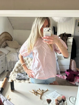 Ljusrosa blus från Saint Tropez - Supersöt ljusrosa blus från Saint Tropez med korta ärmar i broderad spets och rund halsringning. Blusen har en avslappnad passform och är gjord i ett lätt och luftigt material, perfekt för vår och sommar.