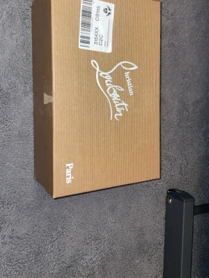 Christian Louboutin Orlato sneakers - Säljer ett par Christian Louboutin Orlato Flat sneakers i färgen svart/marinblå med glitterdetaljer. Skorna har en klassisk låg siluett och är tillverkade i exklusiva material som ger en lyxig känsla. Perfekta för dig som vill sticka ut med stil.