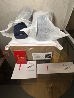 Marinblå sneakers från Louboutin - Snygga marinblå sneakers från Christian Louboutin med klassisk röd sula och ovandel i mocka.priset går att diskutera vid snabb affär 🚚💨