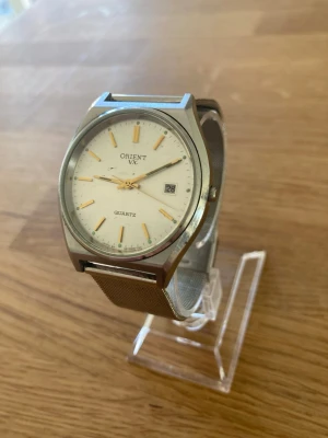 1980 Orient VX Date 36mm Herrur - Säljer en riktigt snygg vintage herrklocka från japanska Orient i mycket gott skick enligt bilder. Fungerar bra, nytt armband i Mesh stål, datumvisare, mineralglas, japanskt urverk, vattentät, osv. Behöver bara nytt batteri.  Begagnat värde: 700+ SEK (exkl. frakt) Mitt pris: 589 SEK  Skickas snabbt och spårbart. Skriv vid frågor och se gärna mina andra annonser!