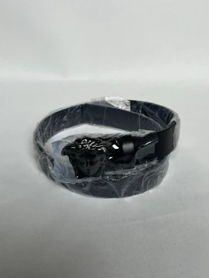 Svart bälte med Medusa-spänne Versace - Stilrent svart bälte från Versace med ikoniskt Medusa-huvud i svart metall som spänne. Bältet är tillverkat i slätt skinn och har en klassisk, tidlös design som lyfter vilken outfit som helst.